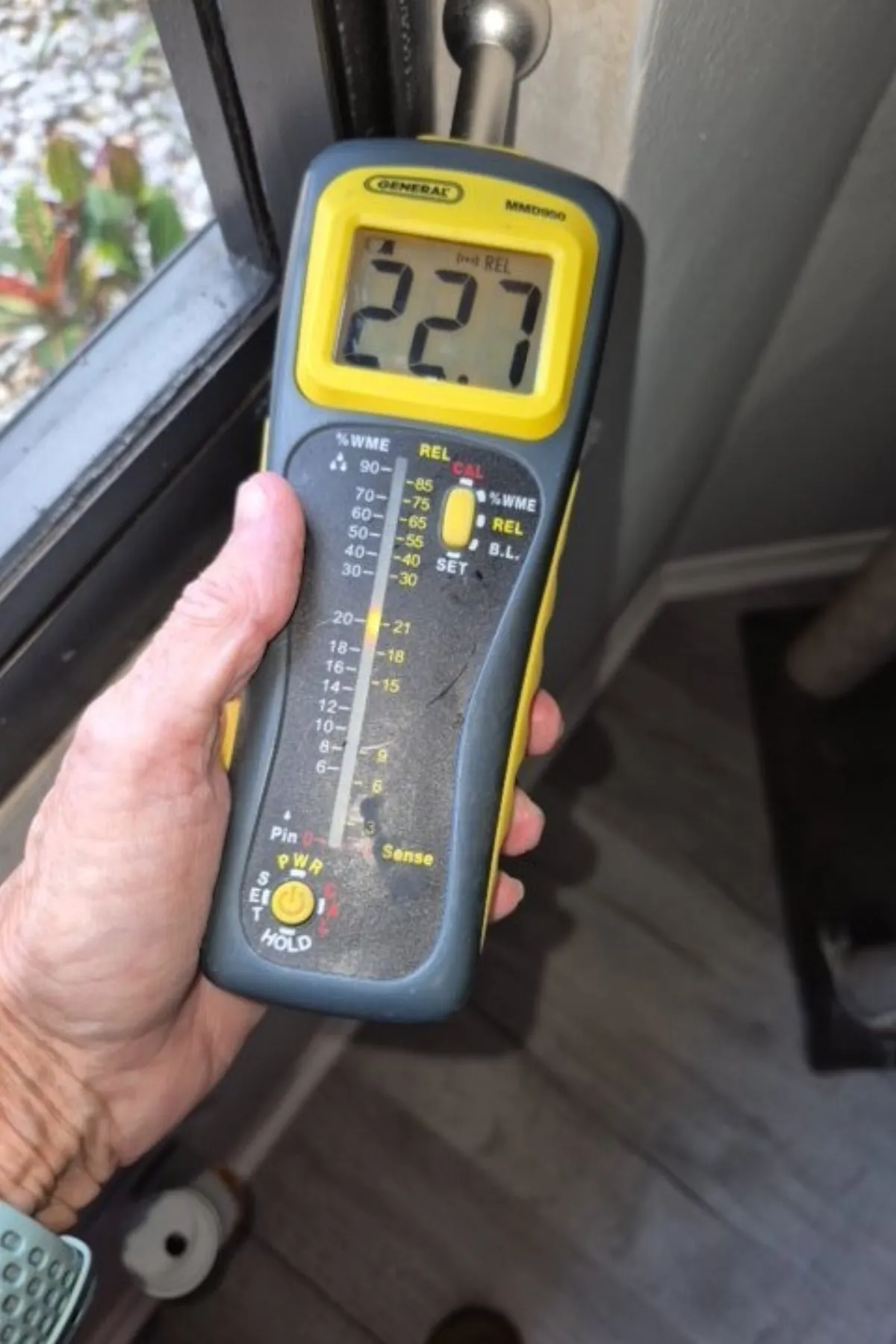 Moisture meter showing elevated readings at a window during a Florida inspection
