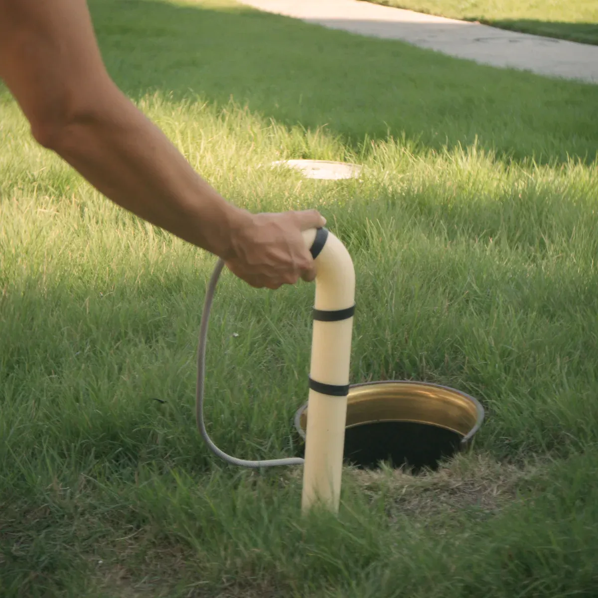 Inspection camera being fed into a sewer cleanout in a Florida lawn