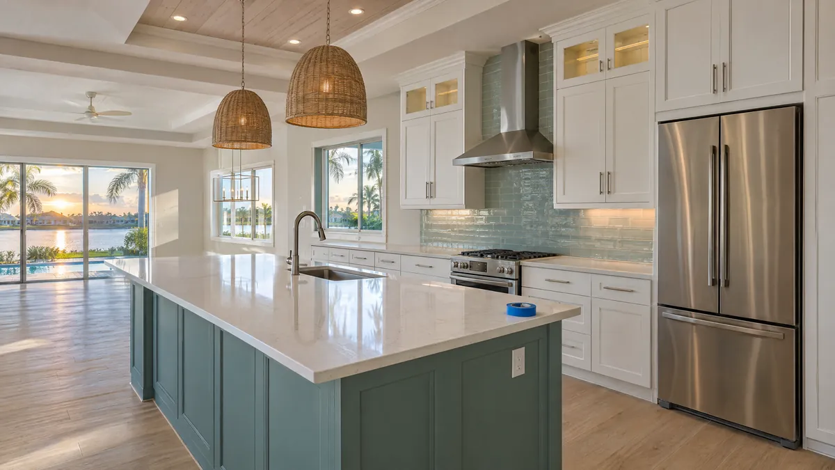 Bright new kitchen with white cabinets and a roll of blue painter's tape on the island